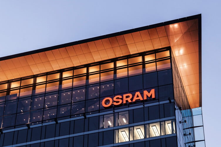 The OSRAM sign on a glass office building at dusk