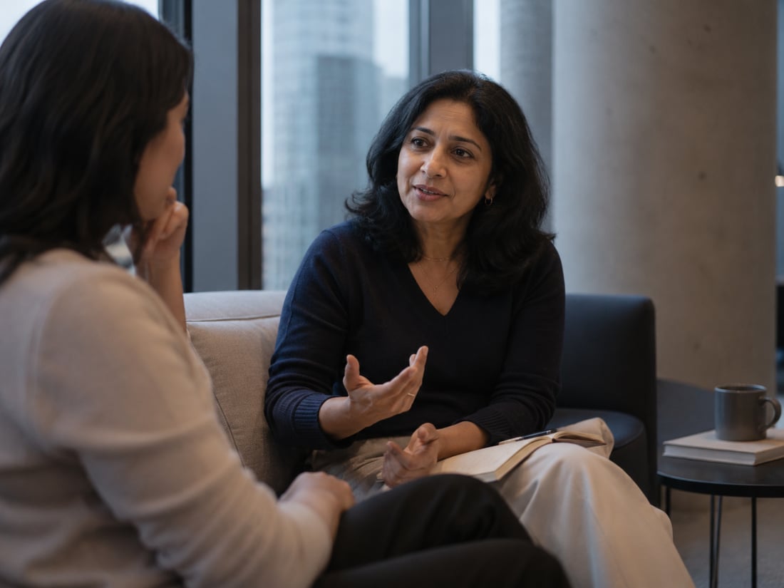 Twee collega's in gesprek in een lounge met uitzicht op de stad