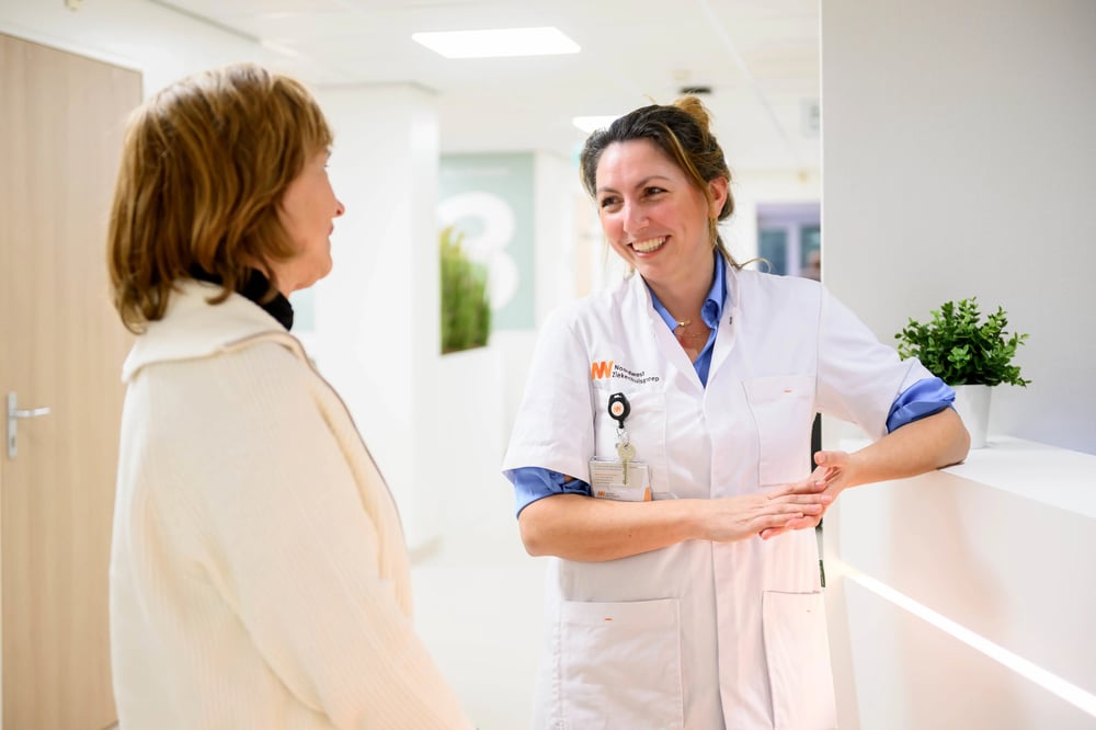 Two Noordwest colleagues in conversation in a hospital corridor