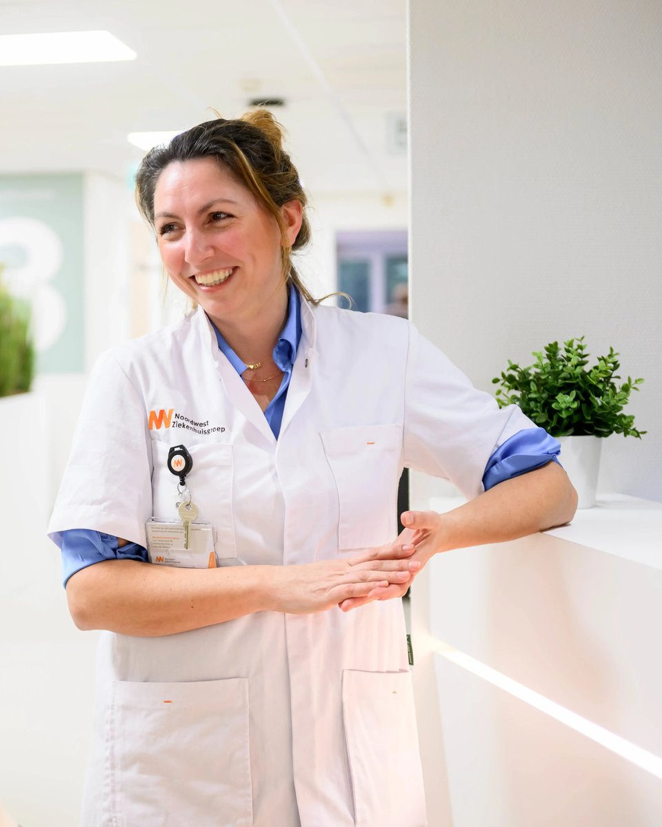 Nurse in conversation with a colleague in a hospital corridor